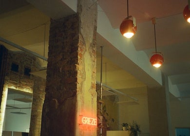 Warm ambiance at Grieze in Rīga, LV with brick walls and red pendant lights.