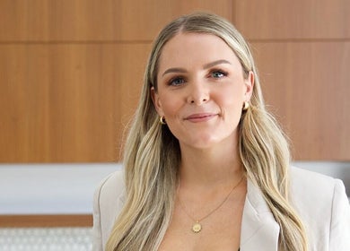 A friendly professional at AR Lash Bar, Mermaid Waters, Queensland, AU, smiling in a stylish office.