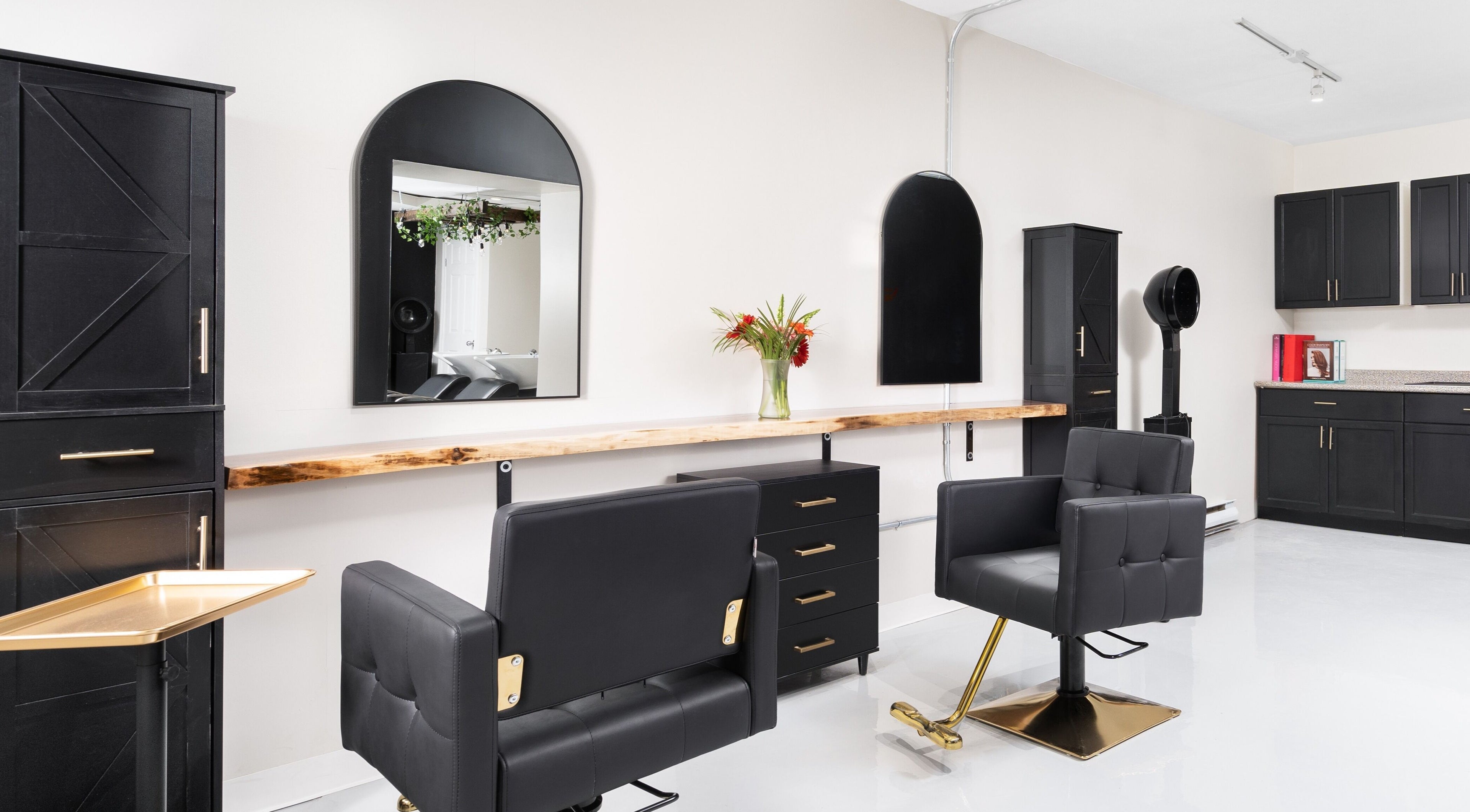 Chic interior of Rustic Roots Hair Lounge, Thorold, Ontario, CA, featuring modern salon chairs and sleek cabinetry.
