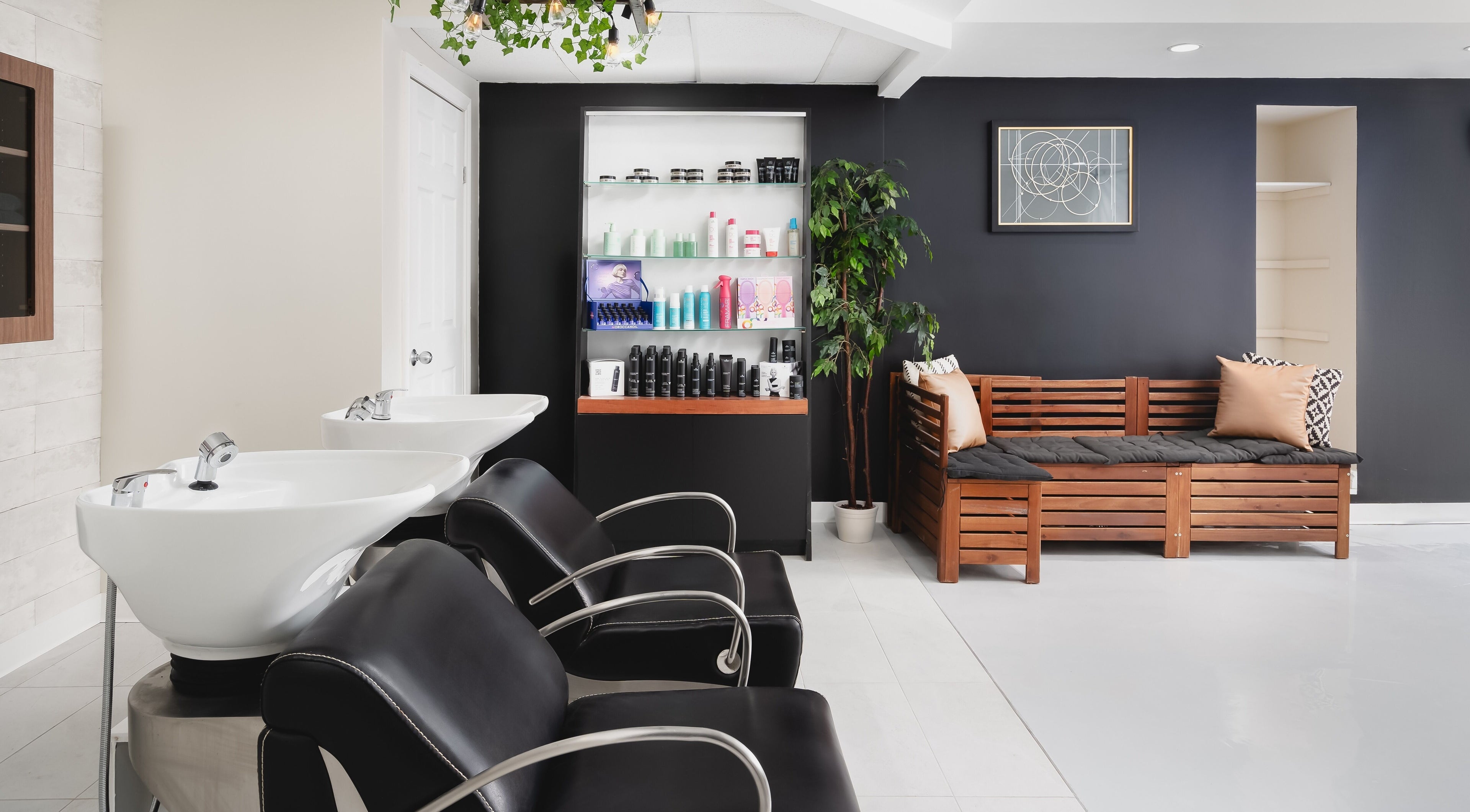 Chic interior of Rustic Roots Hair Lounge in Thorold, Ontario, CA, featuring modern black chairs and wooden decor.