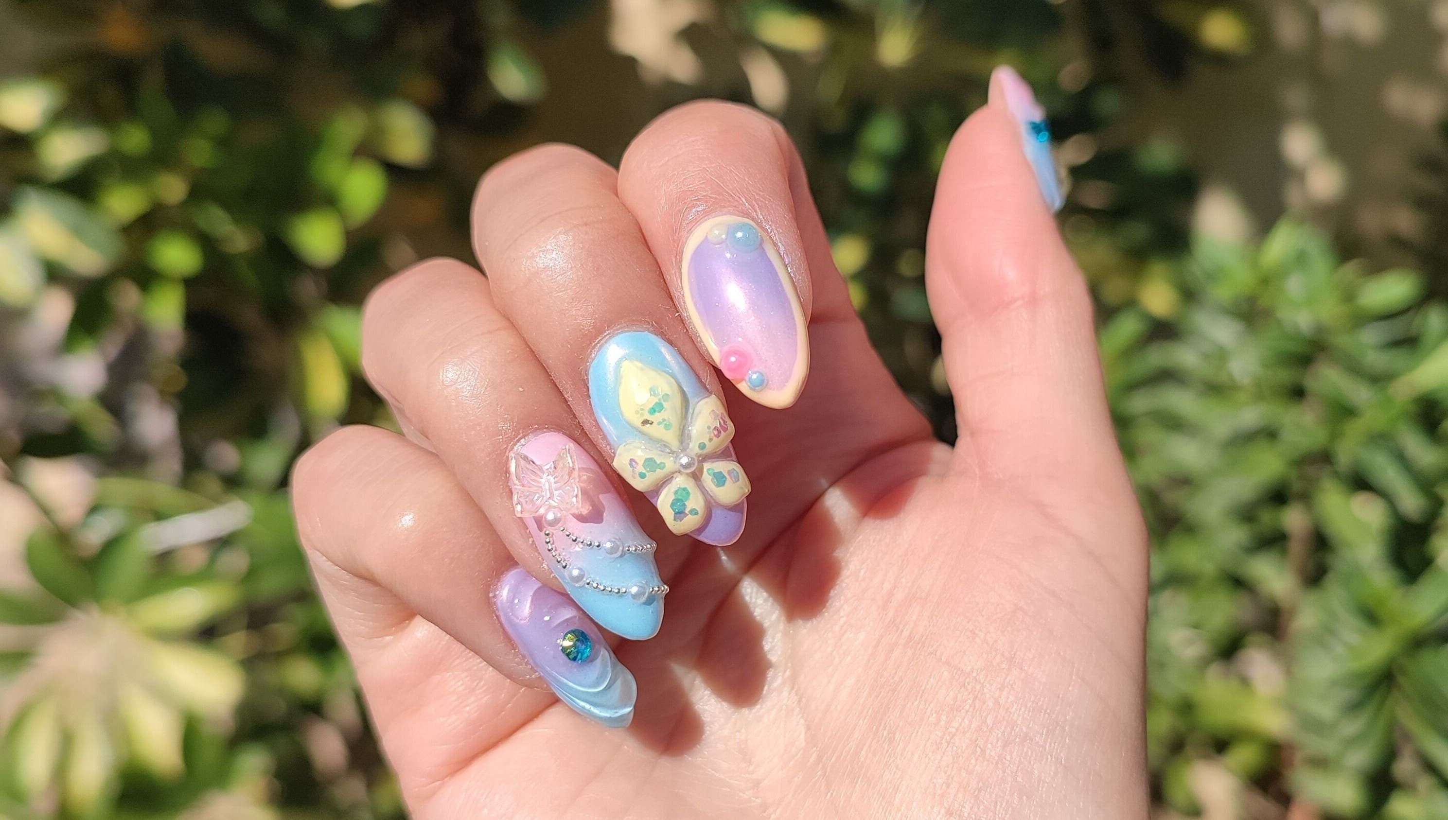 Exquisito arte de uñas en Lisi Nails, Providencia, Región Metropolitana, CL, con mariposas y tonos pastel.