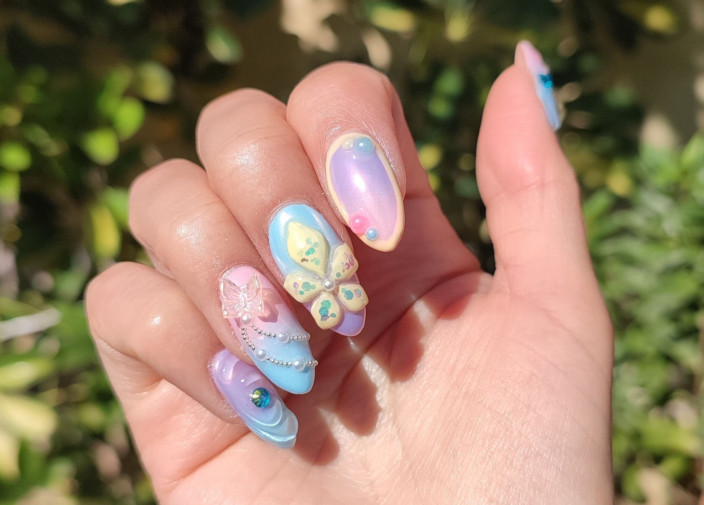 Exquisito arte de uñas en Lisi Nails, Providencia, Región Metropolitana, CL, con mariposas y tonos pastel.