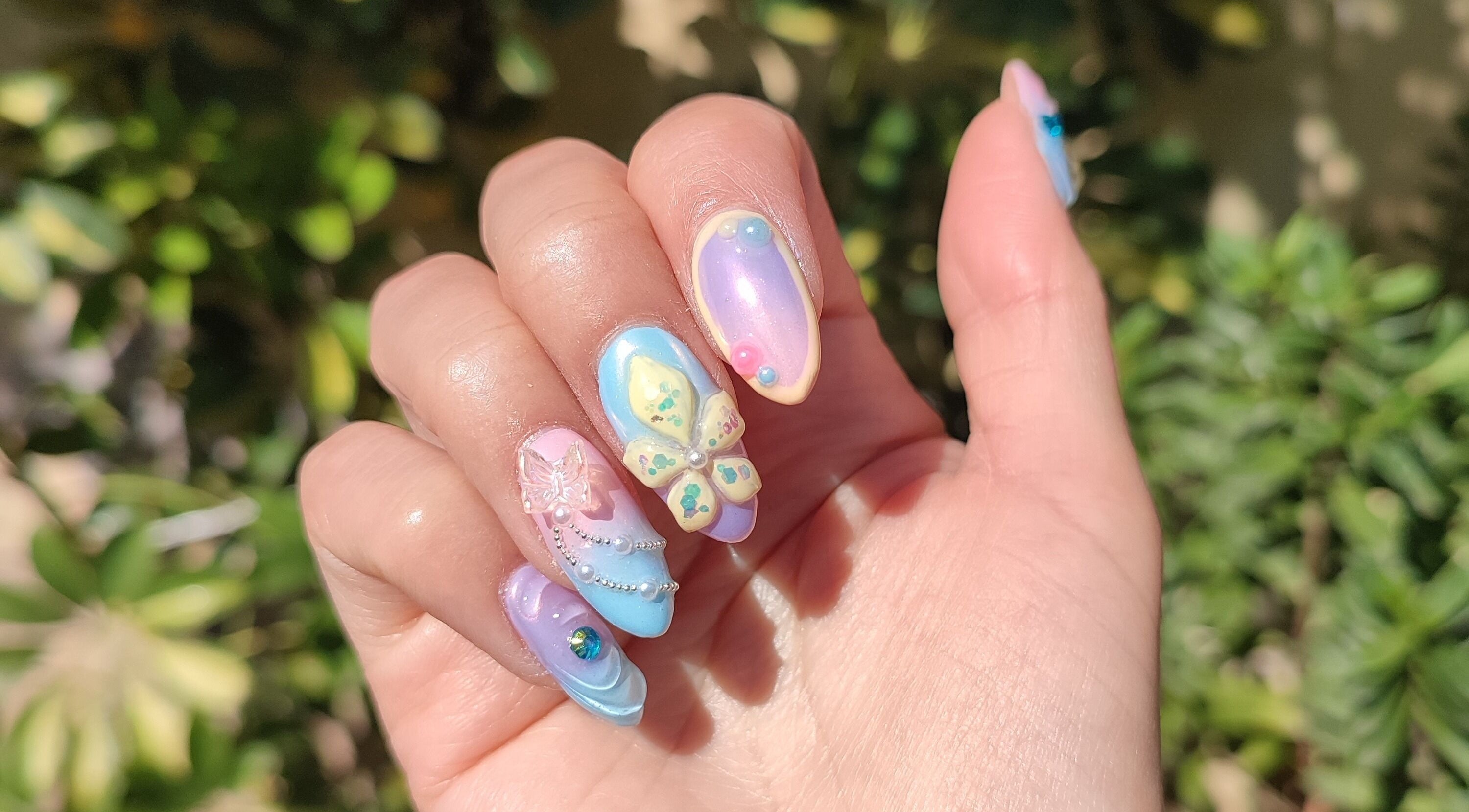 Exquisito arte de uñas en Lisi Nails, Providencia, Región Metropolitana, CL, con mariposas y tonos pastel.