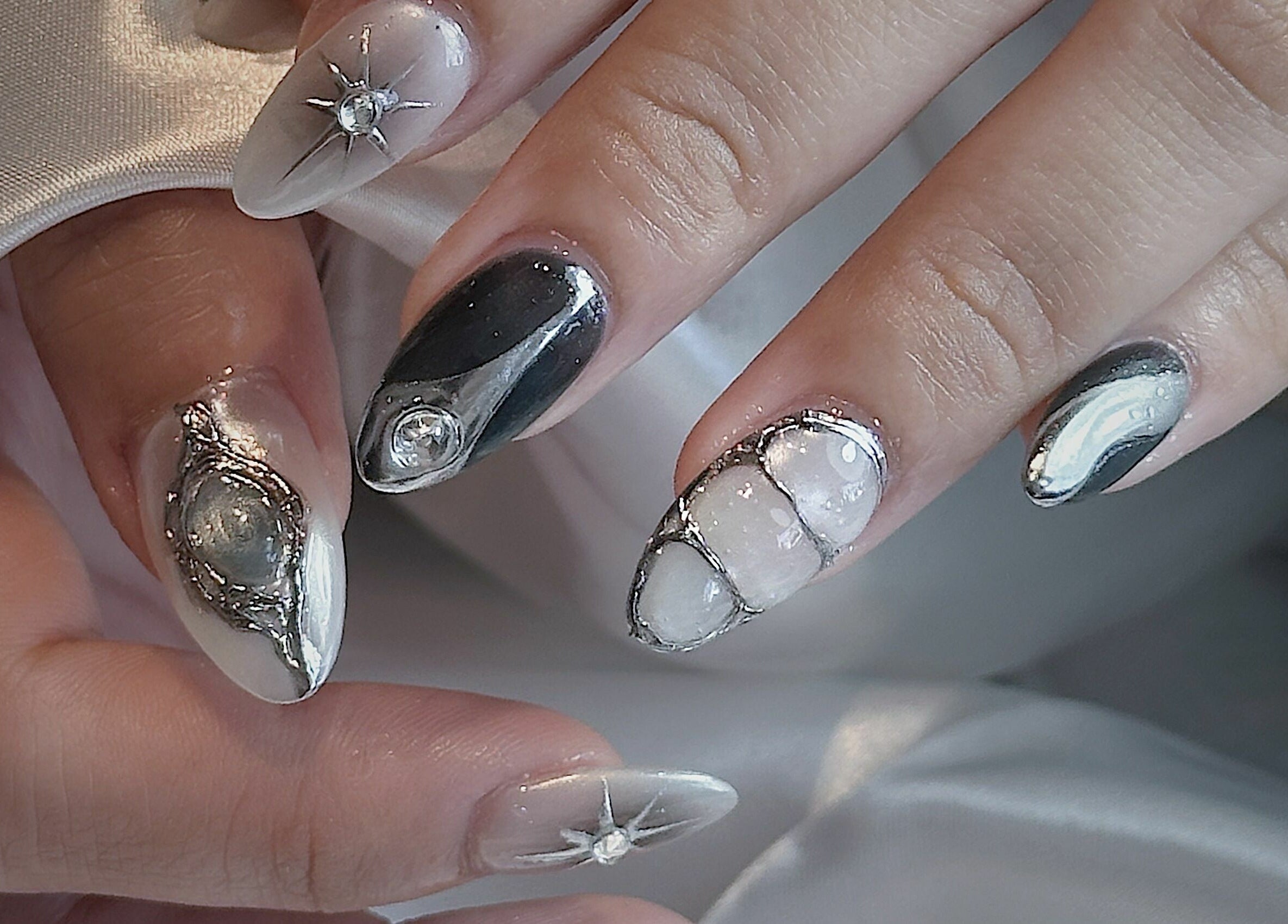 Intricate galactic nail art at Cosmo Nails & Beauty, Auckland, NZ, showcasing unique gemstone and silver designs.