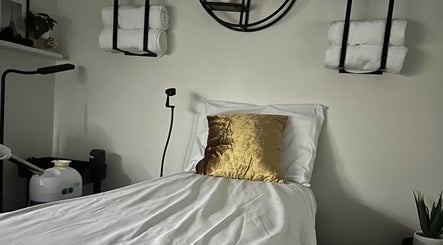 Serene treatment room at Modest Skin, San Diego, California, US with plush bed and golden decor.