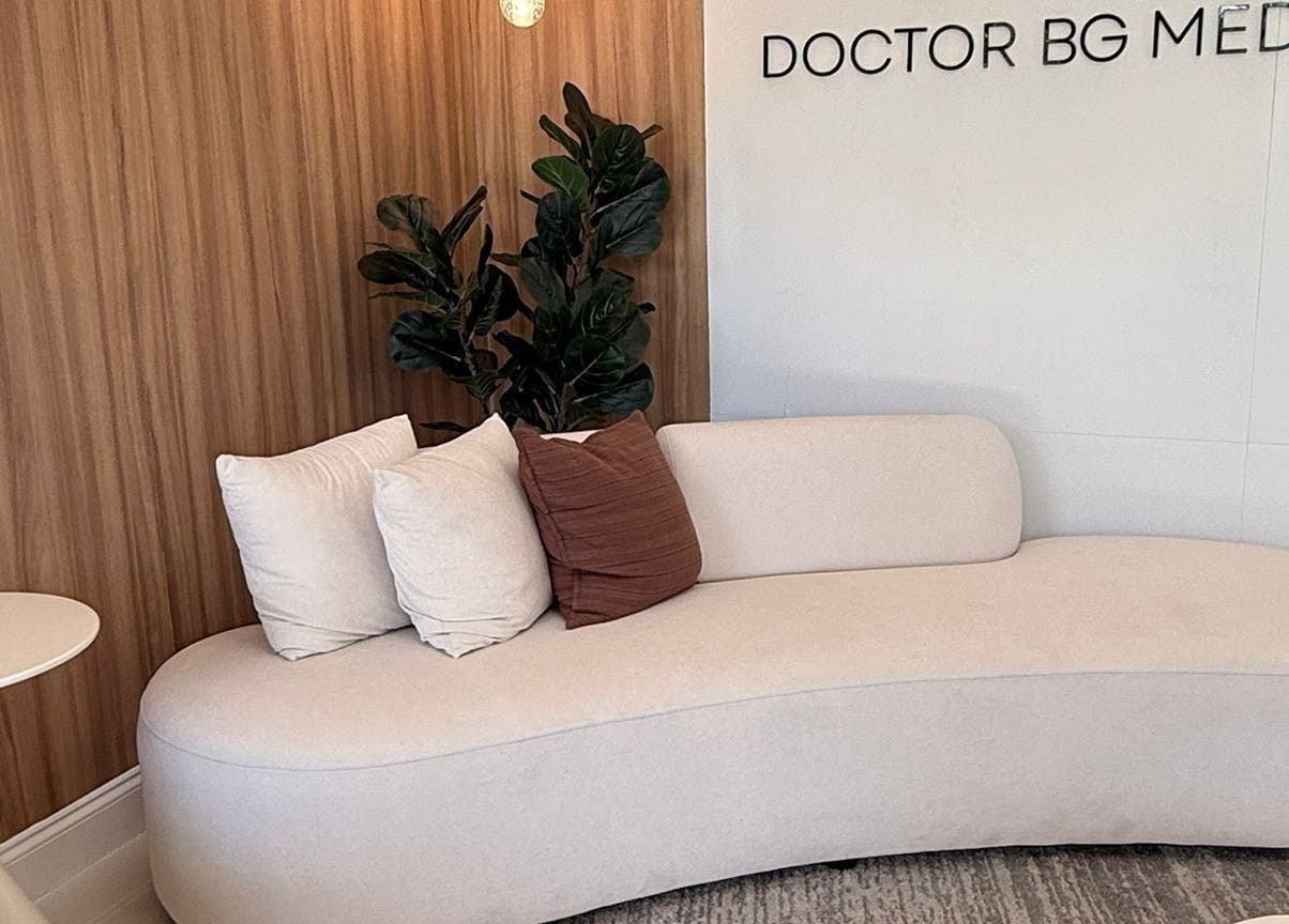 Elegant seating area at BG Studio Salon, Coconut Creek, Florida, US, featuring a plush sofa and decorative pillows.