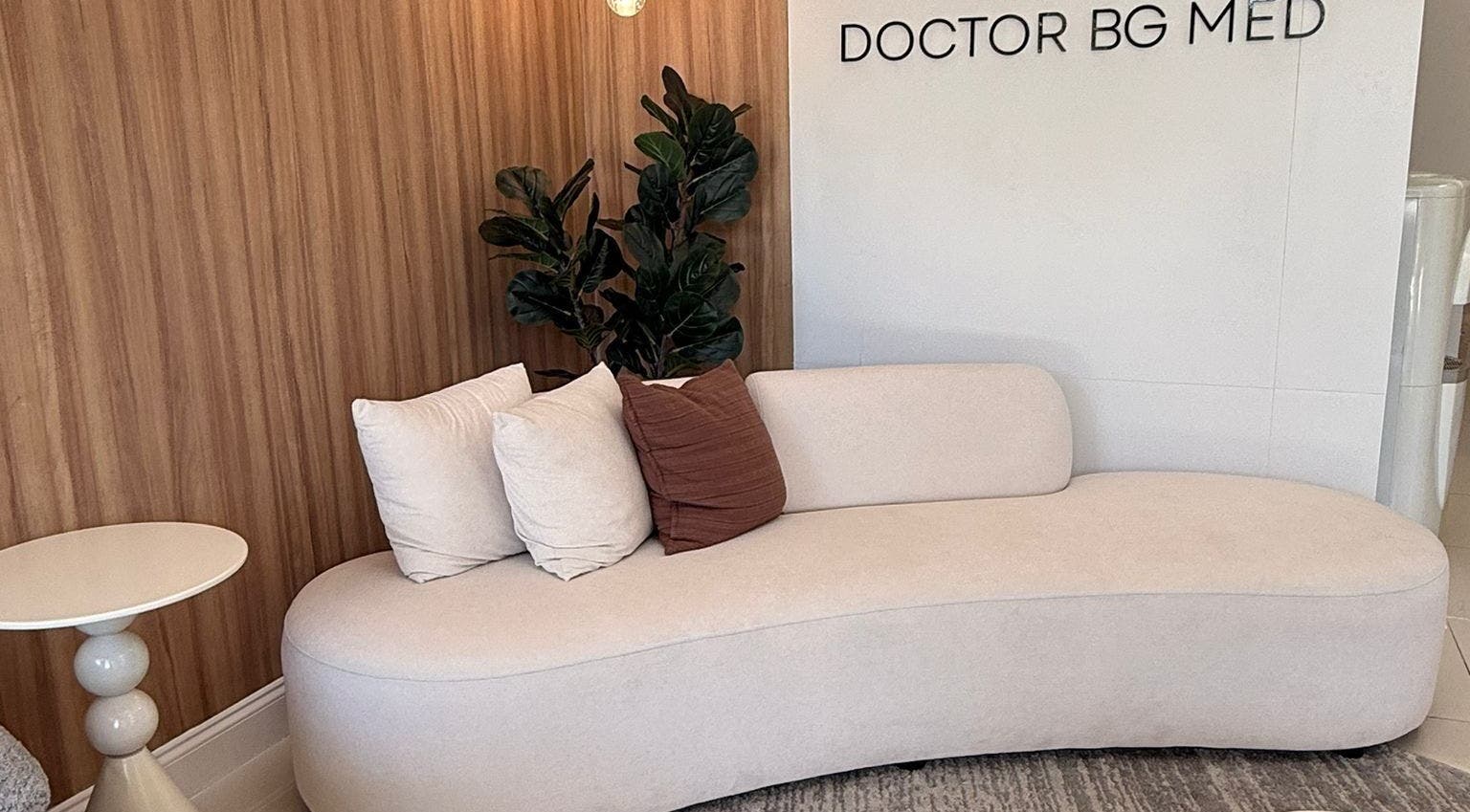 Elegant seating area at BG Studio Salon, Coconut Creek, Florida, US, featuring a plush sofa and decorative pillows.