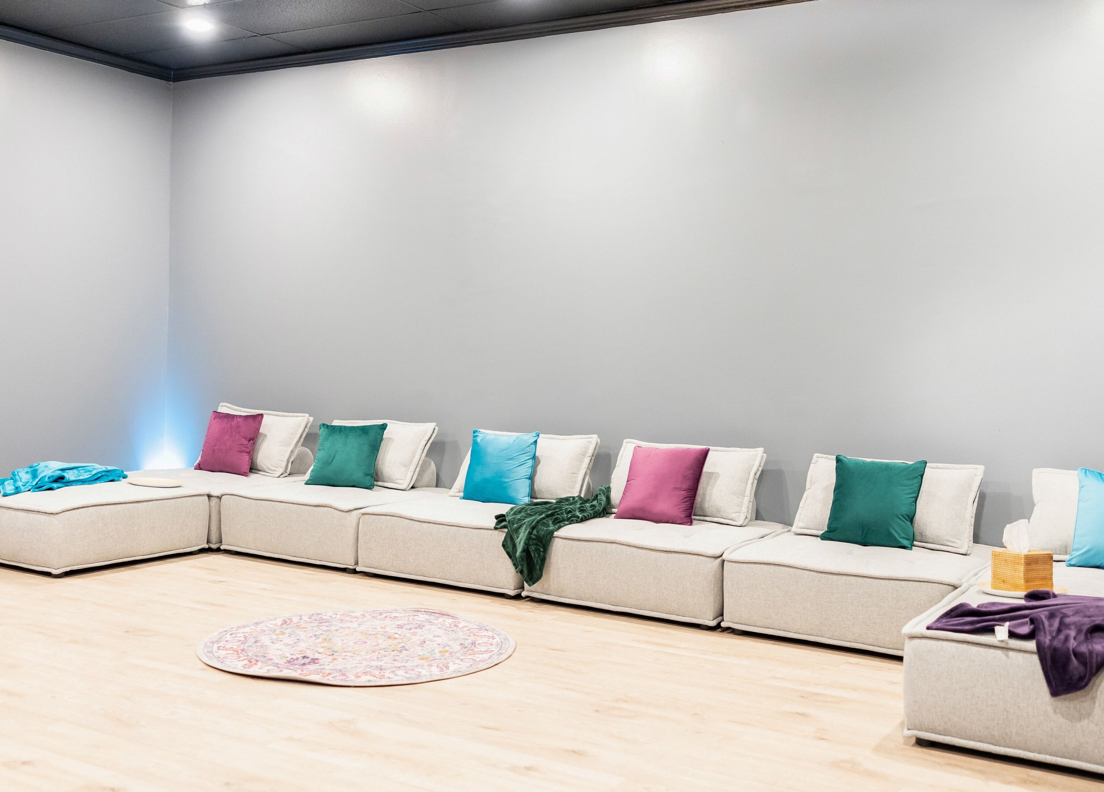 Relaxing lounge with colorful cushions at Aura Holistic and Metaphysical Wellness, Spring, Texas, US.