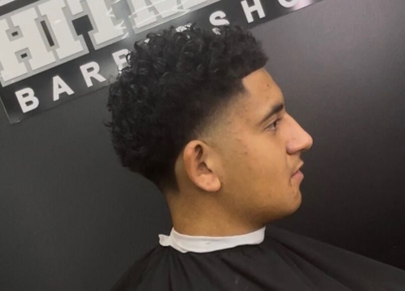Man with a curly fade haircut at Hitman Barbershop in Yarrabilba, Queensland, AU.