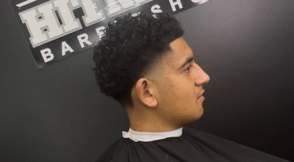 Man with a curly fade haircut at Hitman Barbershop in Yarrabilba, Queensland, AU.