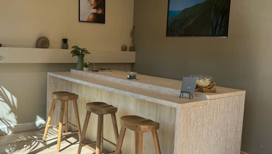 Modern reception area at Gels By Kayles in Taunton, England, GB with wooden stools and minimalist decor.