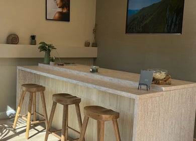 Modern reception area at Gels By Kayles in Taunton, England, GB with wooden stools and minimalist decor.