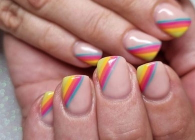 Vibrant rainbow nail art at Mooi Getooi, Douglas, Northern Cape, ZA. Hands with colorful, striped manicure.