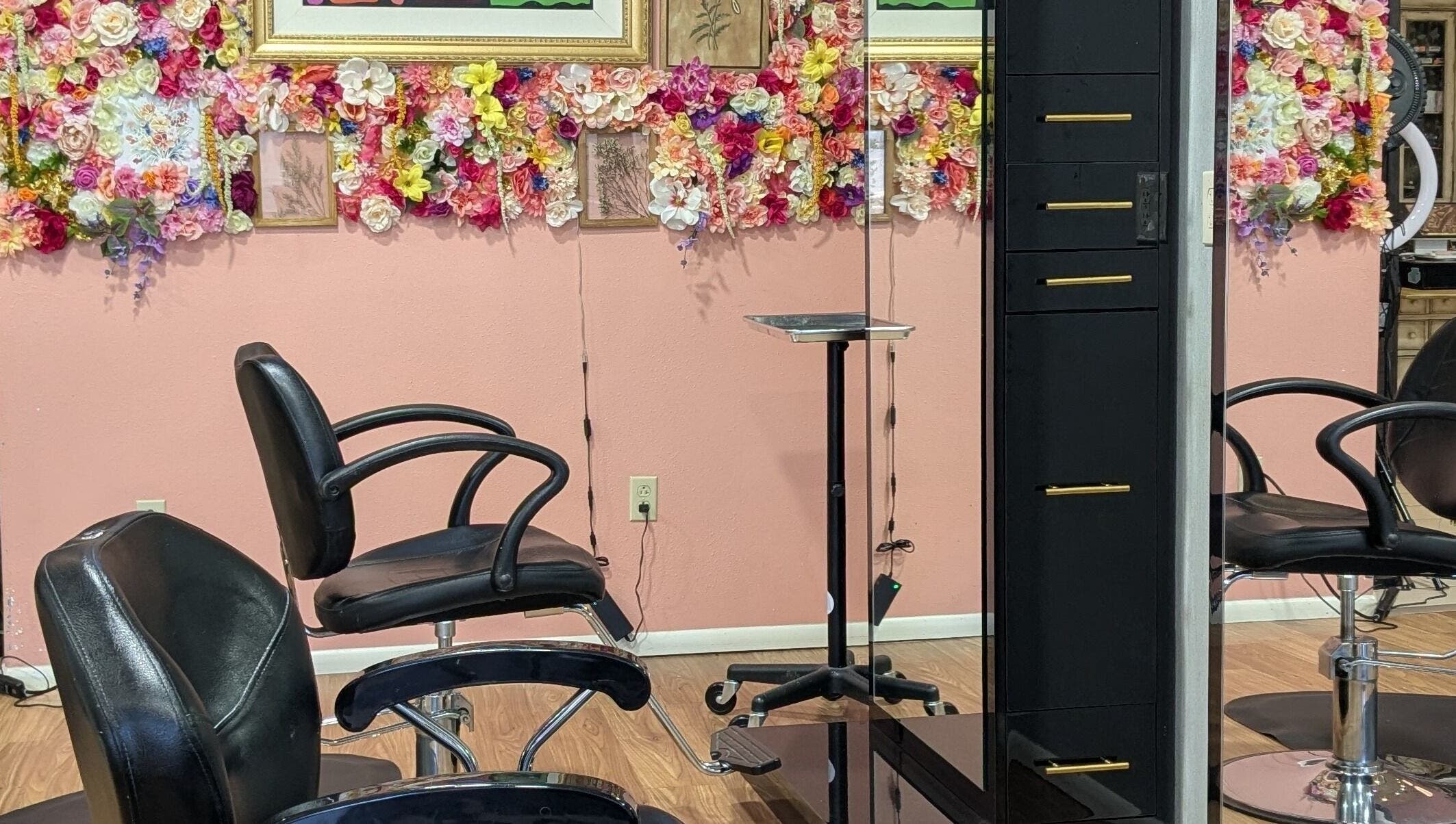 Stylish salon chairs at A&A Beauty Bar Llc, Santa Fe, New Mexico, US, with a vibrant floral wall feature.
