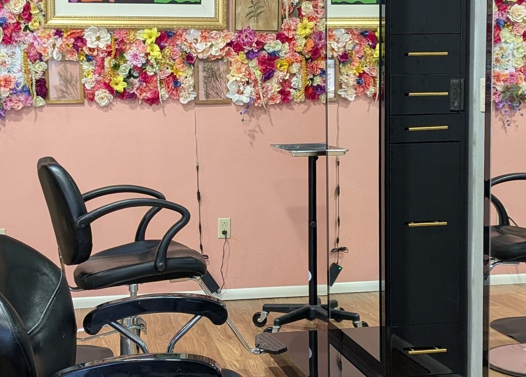 Stylish salon chairs at A&A Beauty Bar Llc, Santa Fe, New Mexico, US, with a vibrant floral wall feature.