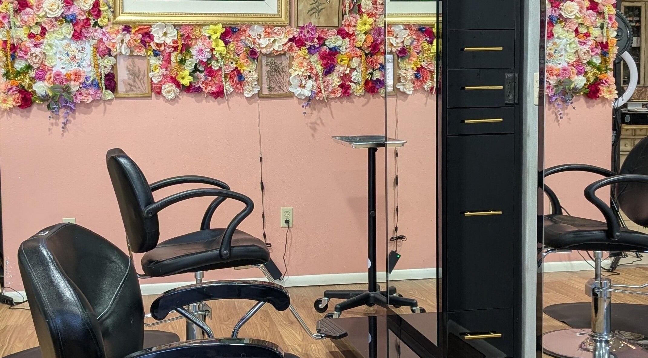 Stylish salon chairs at A&A Beauty Bar Llc, Santa Fe, New Mexico, US, with a vibrant floral wall feature.