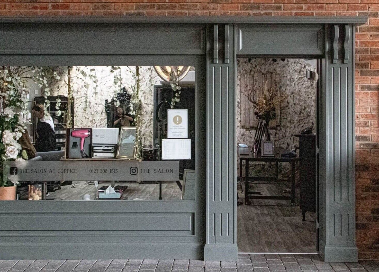 Front view of The Salon in Tamworth, England, GB showcasing a chic entrance with floral decor.