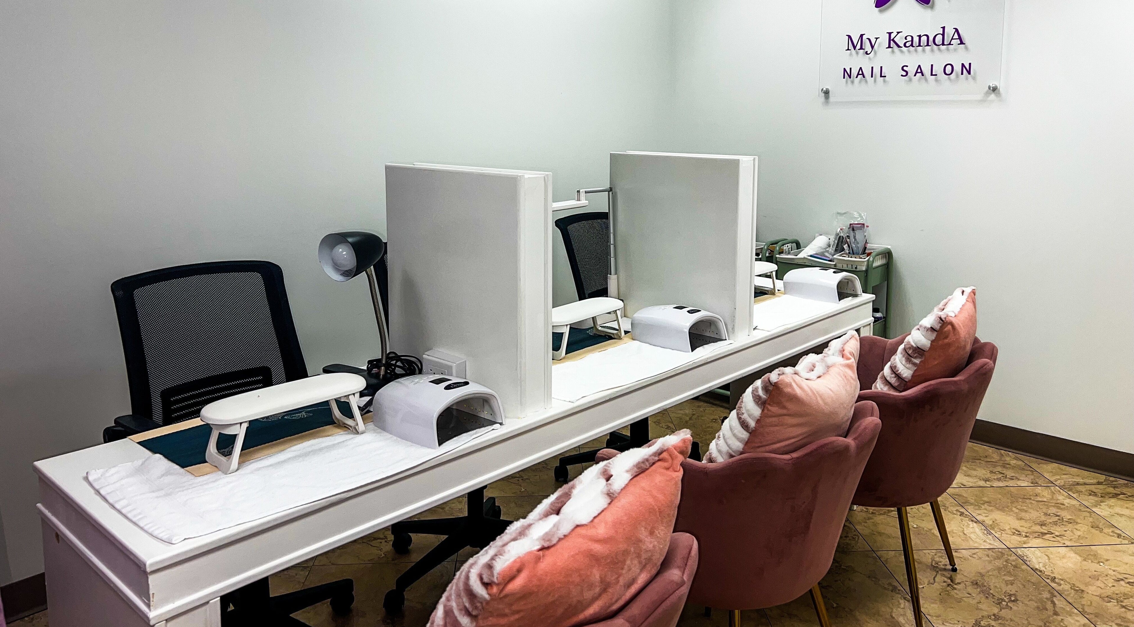 Chic nail stations at My KandA Nail Salon, Grand Cayman, showcasing stylish decor and plush chairs.