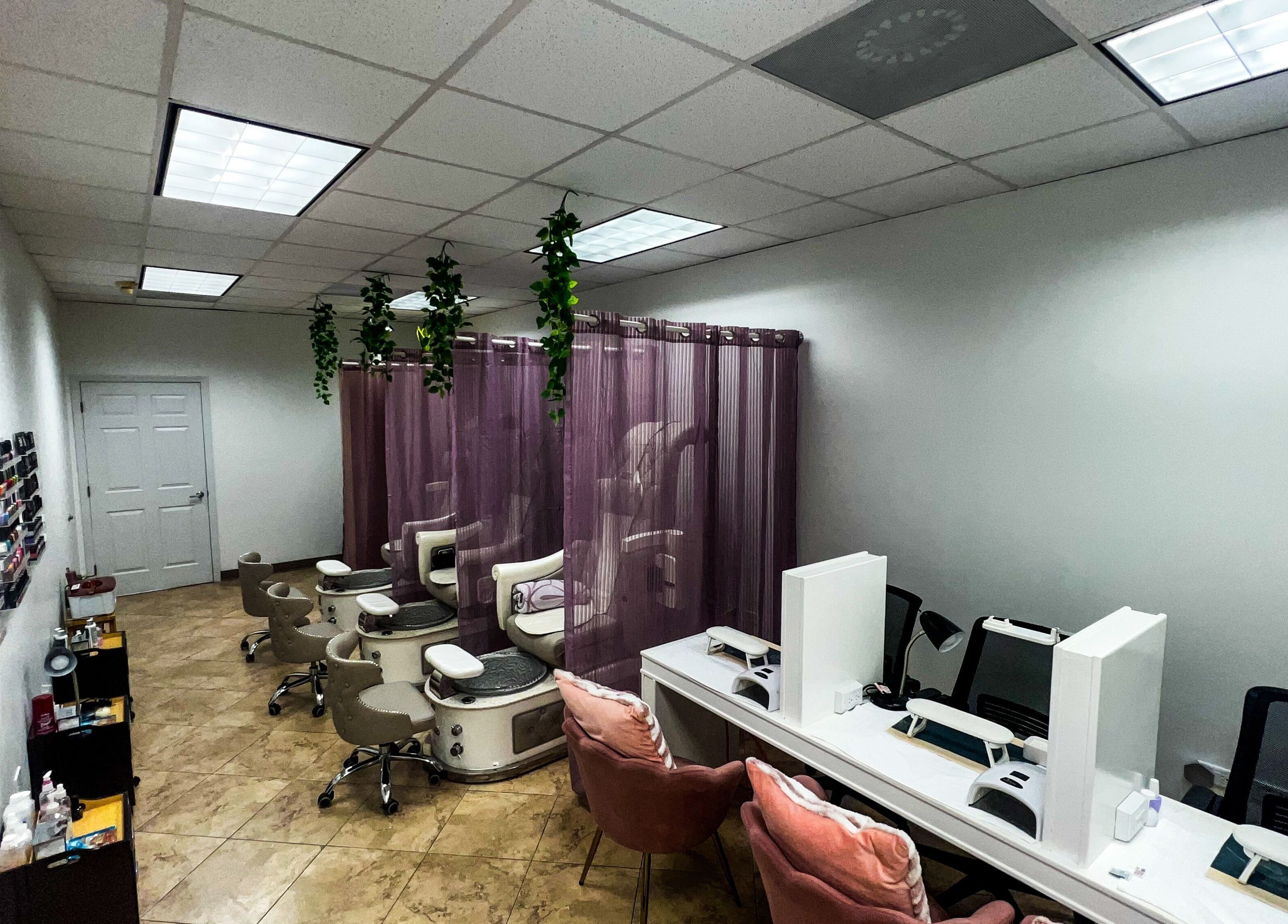 Interior of My KandA Nail Salon, Grand Cayman, featuring pedicure chairs and manicure stations with soft lighting.