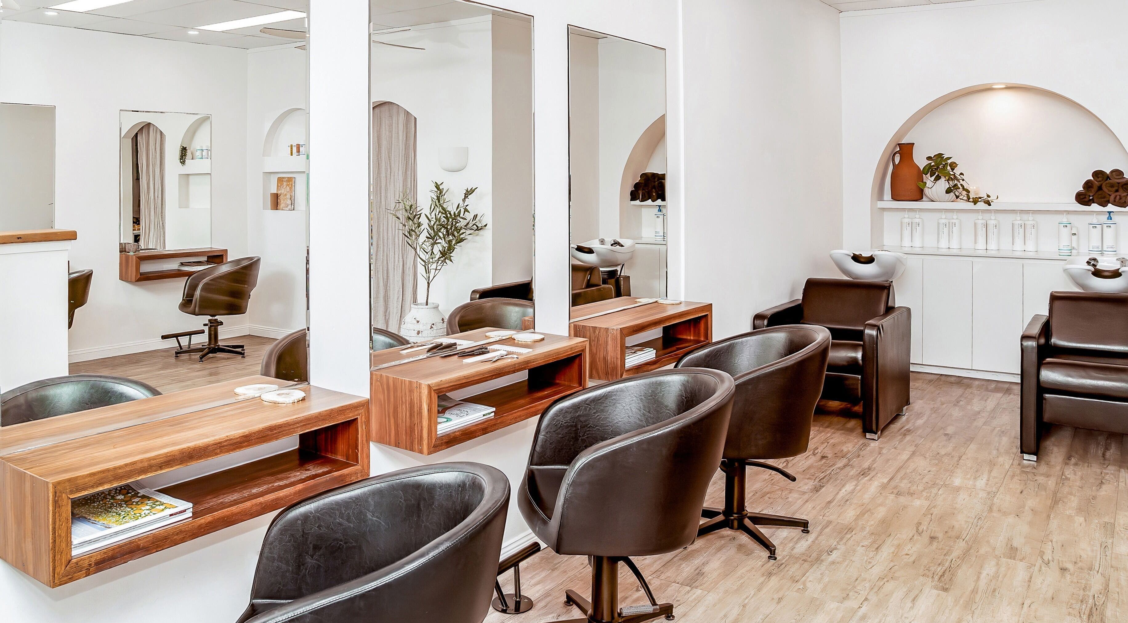 Modern interior of Urban Earth Hair Studio in Lennox Head, New South Wales, AU, featuring sleek salon chairs and decor.
