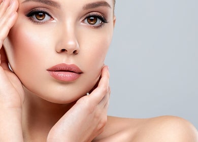 Close-up of a model's glowing skin embraced by her hands at Aesthetic Medical LTD, Trowbridge, England, GB.