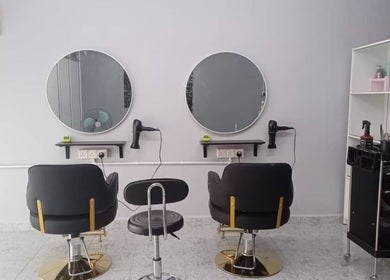 Modern styling area at Erma Hair Studio, Kangar, Perlis, MY, featuring sleek chairs and round mirrors.