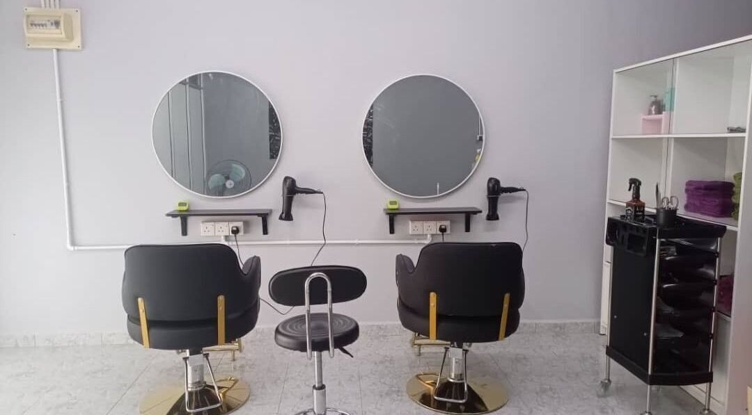 Modern styling area at Erma Hair Studio, Kangar, Perlis, MY, featuring sleek chairs and round mirrors.