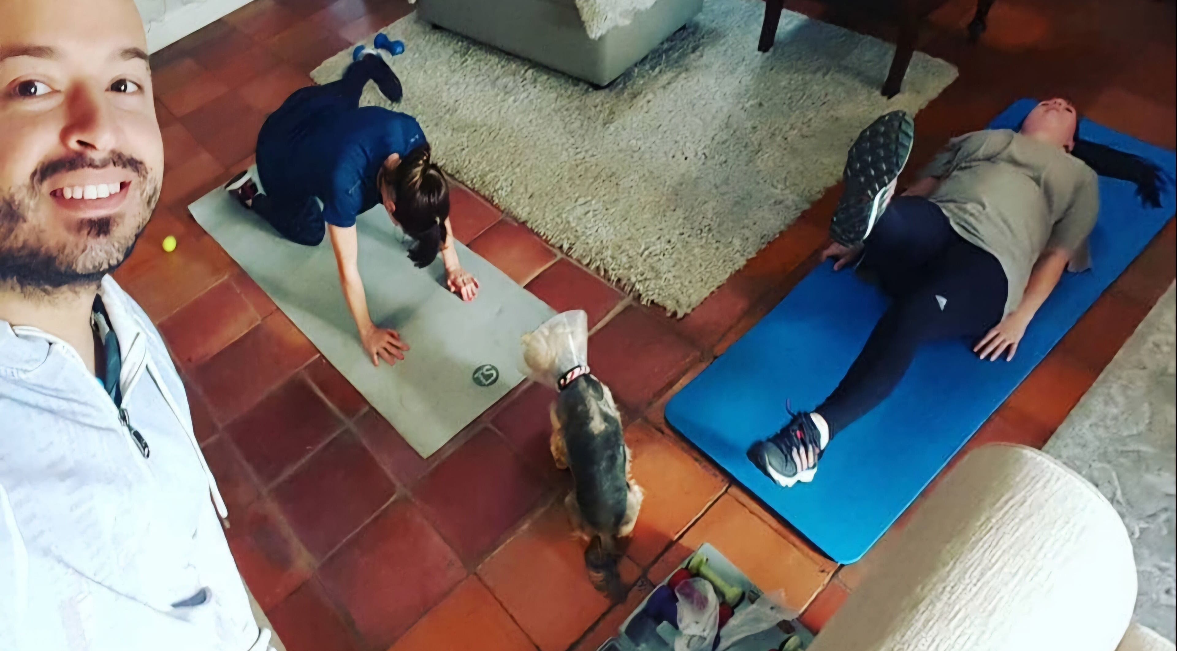 JK Personal Trainer leads a cozy indoor workout session in Cape Town, Western Cape, ZA with a playful pet.