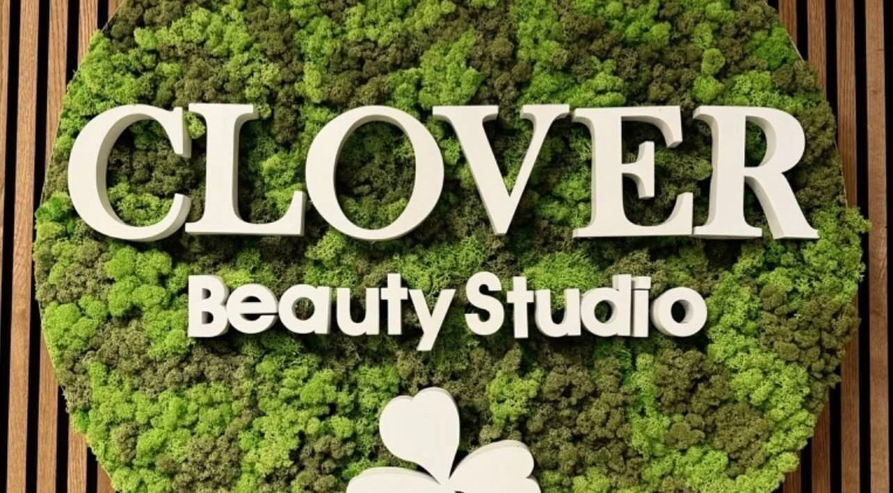 Green wall sign of Clover Beauty Studio Limited, located in Ennis, County Clare, IE, showcasing natural design.