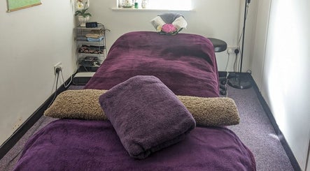 Tranquil massage room at AK Thai Solution Massage in Dudley, England, GB with plush purple towels.