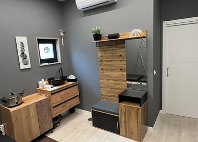 Sala de masajes moderna en Beganur Massages, Santiago De Compostela, ES con decoración de madera y lavabo.