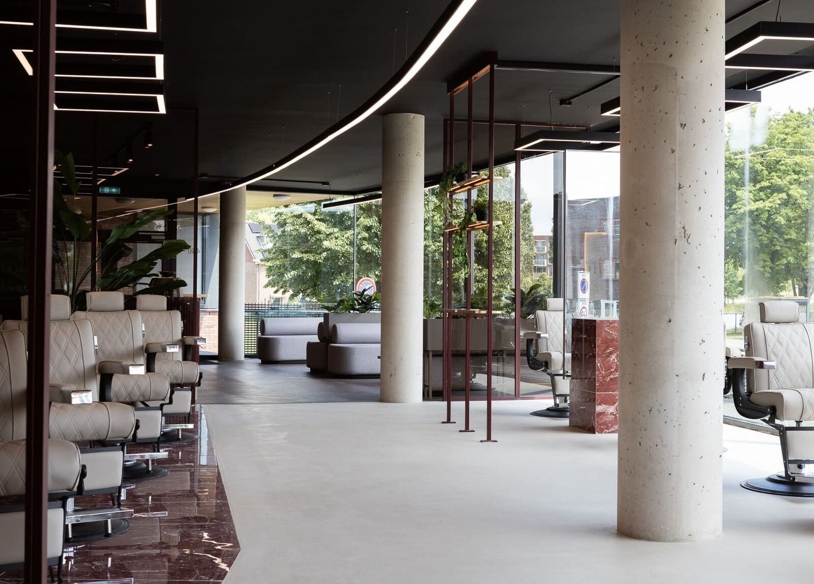 Moderne interieur van The Realest Barbers Leidsche Rijn in Utrecht, met strakke stoelen en grote ramen.