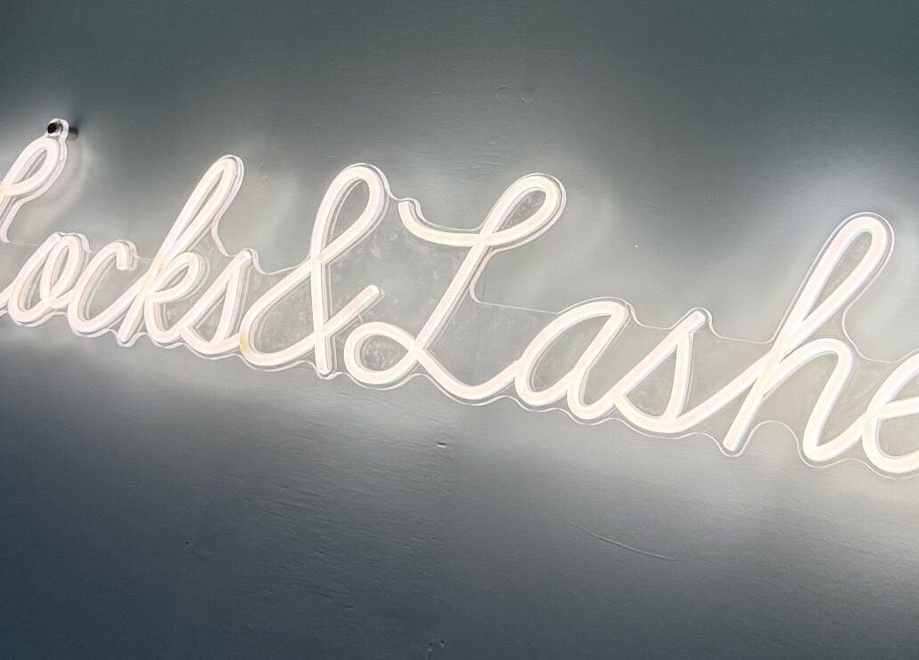 Neon sign of 'Locks and Lashes' at Cambridge, England, GB, highlighting the beauty and wellness venue.