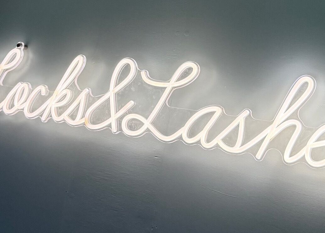 Neon sign of 'Locks and Lashes' at Cambridge, England, GB, highlighting the beauty and wellness venue.