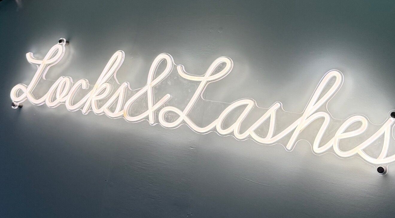 Neon sign of 'Locks and Lashes' at Cambridge, England, GB, highlighting the beauty and wellness venue.