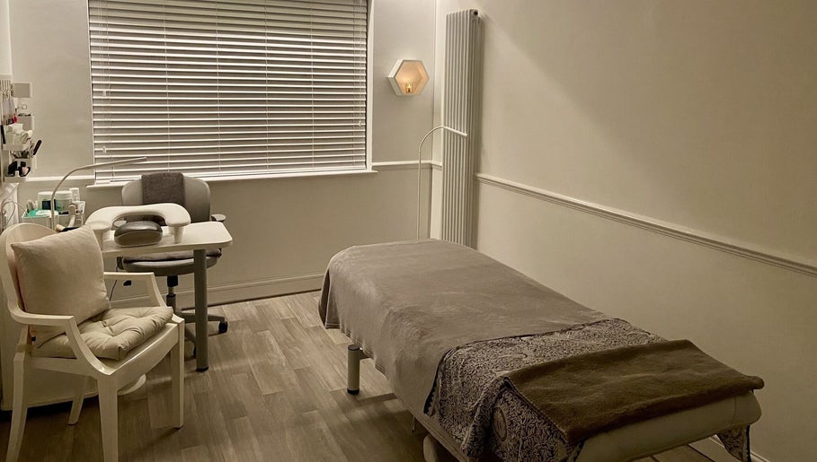 Relaxing treatment room at Wanderlust Beauty & Foot Health, Westoning, England, GB, with a massage bed and chair.