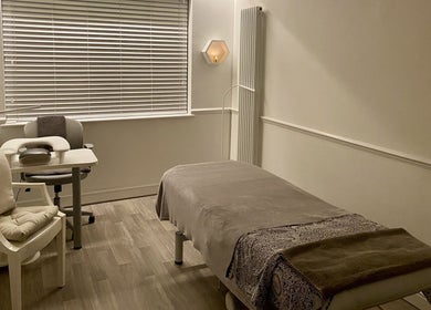 Relaxing treatment room at Wanderlust Beauty & Foot Health, Westoning, England, GB, with a massage bed and chair.