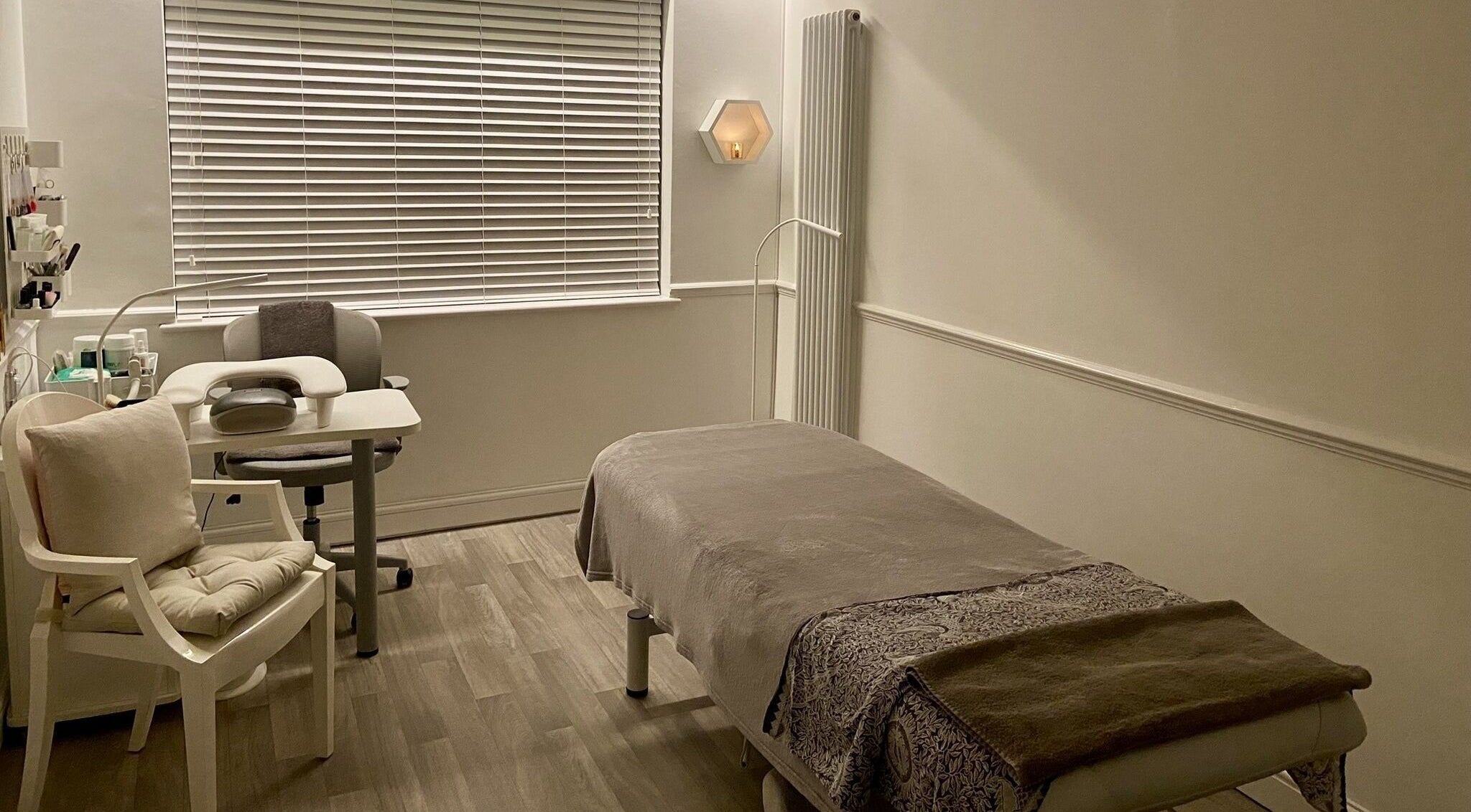 Relaxing treatment room at Wanderlust Beauty & Foot Health, Westoning, England, GB, with a massage bed and chair.