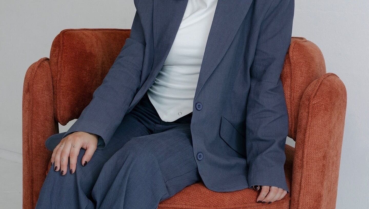 Person in blue suit seated on a cozy chair at Hair.ByTayah, Berkeley Vale, New South Wales, AU.