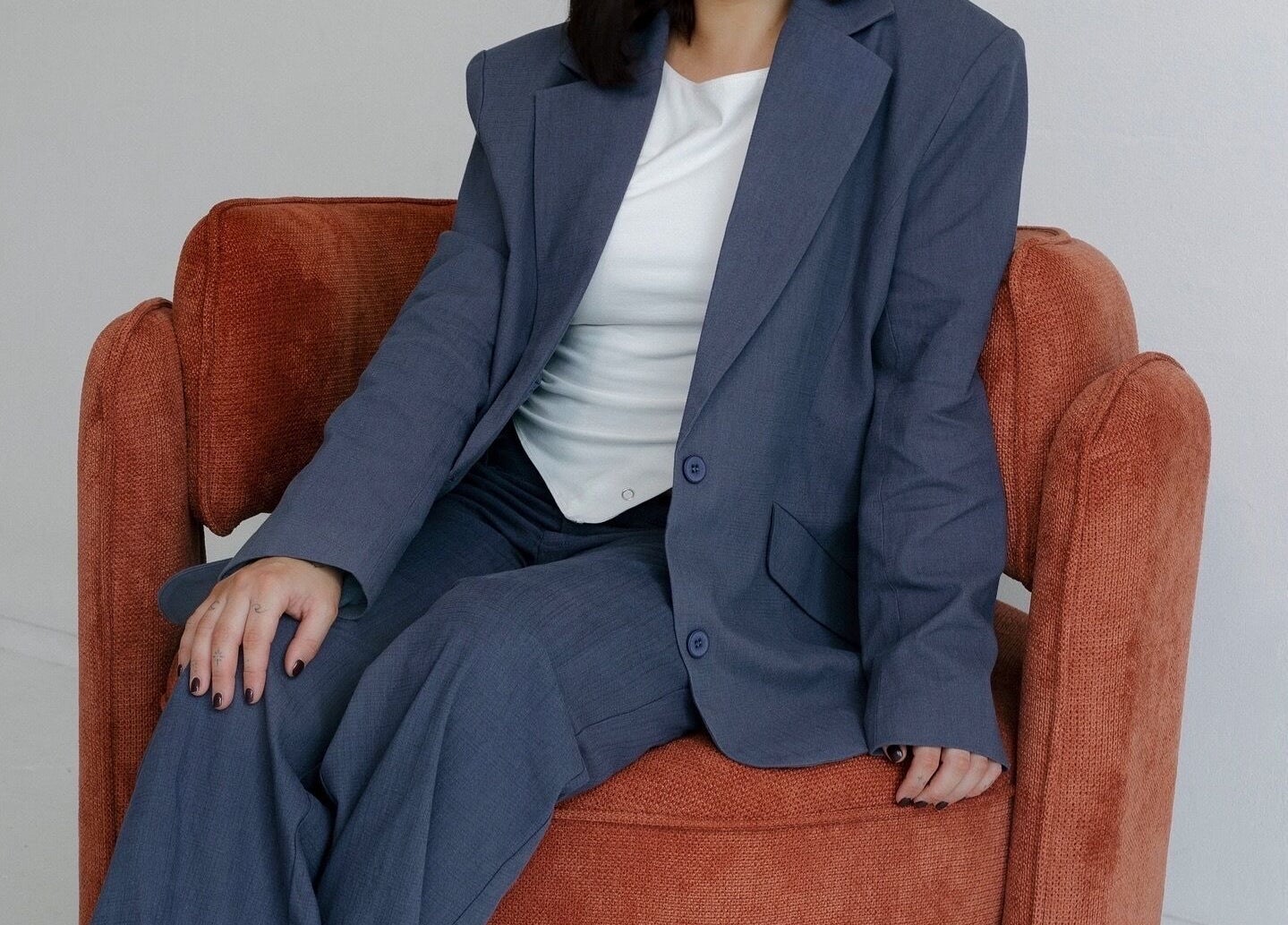 Person in blue suit seated on a cozy chair at Hair.ByTayah, Berkeley Vale, New South Wales, AU.