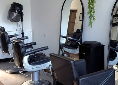 Spacious, modern salon interior at Giuseppe’s of Bath, Bath, England, GB with stylish chairs and large mirrors.