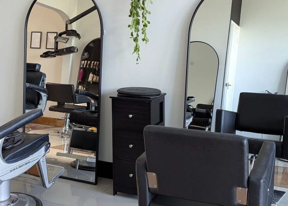Elegant salon setup at Giuseppe’s of Bath, featuring sleek black chairs and mirrors in Bath, England, GB.