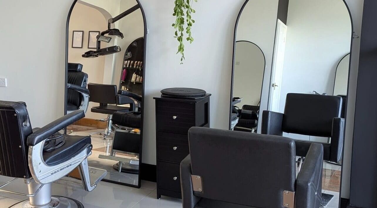 Elegant salon setup at Giuseppe’s of Bath, featuring sleek black chairs and mirrors in Bath, England, GB.