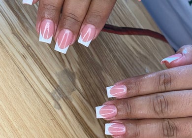 Beautiful French manicure at AllurebeautybyC_ in Cape Town, Western Cape, ZA with a wooden background.