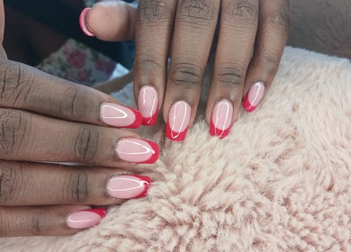 Red-tipped manicured nails from X Nails and Beauty, Ballito, Kwazulu-natal, ZA on a soft surface.