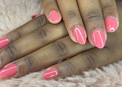 Stylish pink nails at X Nails and Beauty in Ballito, Kwazulu-Natal, ZA on a cozy fur surface.