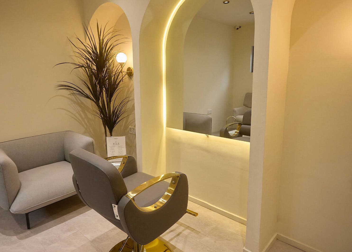 A cozy styling area in CBK Beauty Flagship Salon, Accra, Greater Accra Region, GH with chic seating and modern lighting.