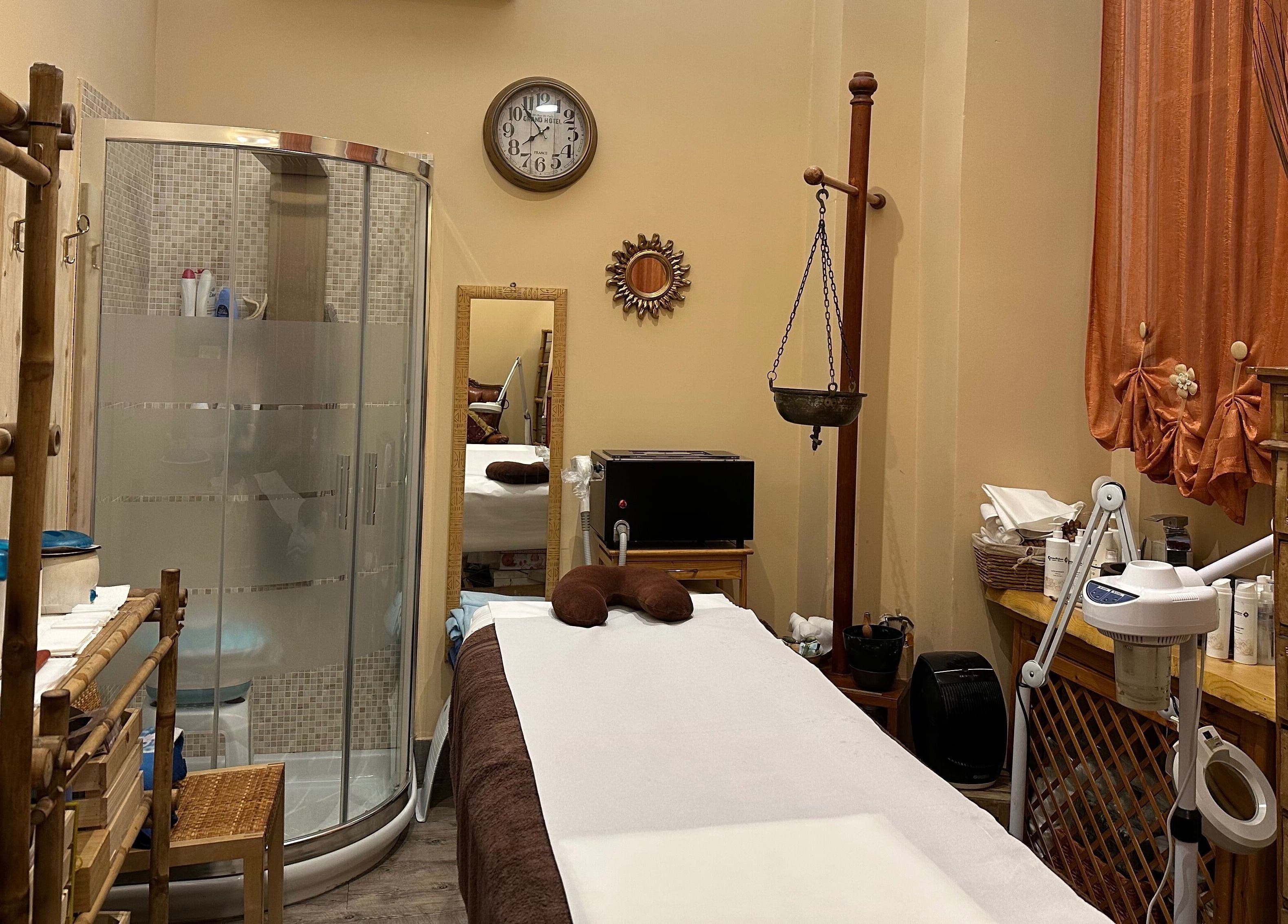 Sala massaggi accogliente presso GocciaDiLuna a Rapallo, Liguria, IT con doccia e decorazioni eleganti.