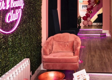 Stylish interior of Megan Eve Hair, Hinckley, England with pink chair and neon sign.
