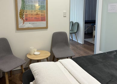 Cozy therapy room at Your Healing Hub & Abiding Body Wellness in Helensvale, Queensland, AU with chairs and massage table.